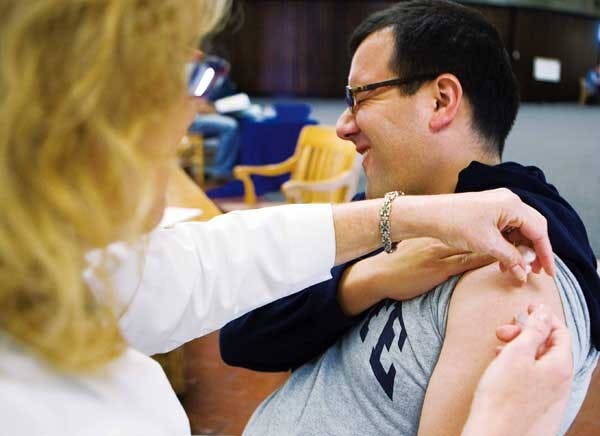 UNM student John Young gets a flu vaccination from Jo Antreasian in the Student Health Center on Tuesday. Shots are $13 for students and $20 for staff, faculty and members of the community. Flu shots are free with Student Health Insurance Plan A.