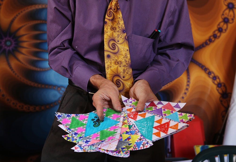 	Jonathan Wolfe holds fractals drawn by school children. Check out page 18 for a profile of the man who dedicated his life to the fractal phenomenon. 