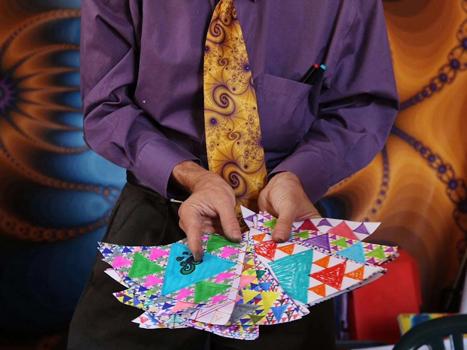Jonathan Wolfe holds fractals drawn by school children. Check out page 18 for a profile of the man who dedicated his life to the fractal phenomenon.