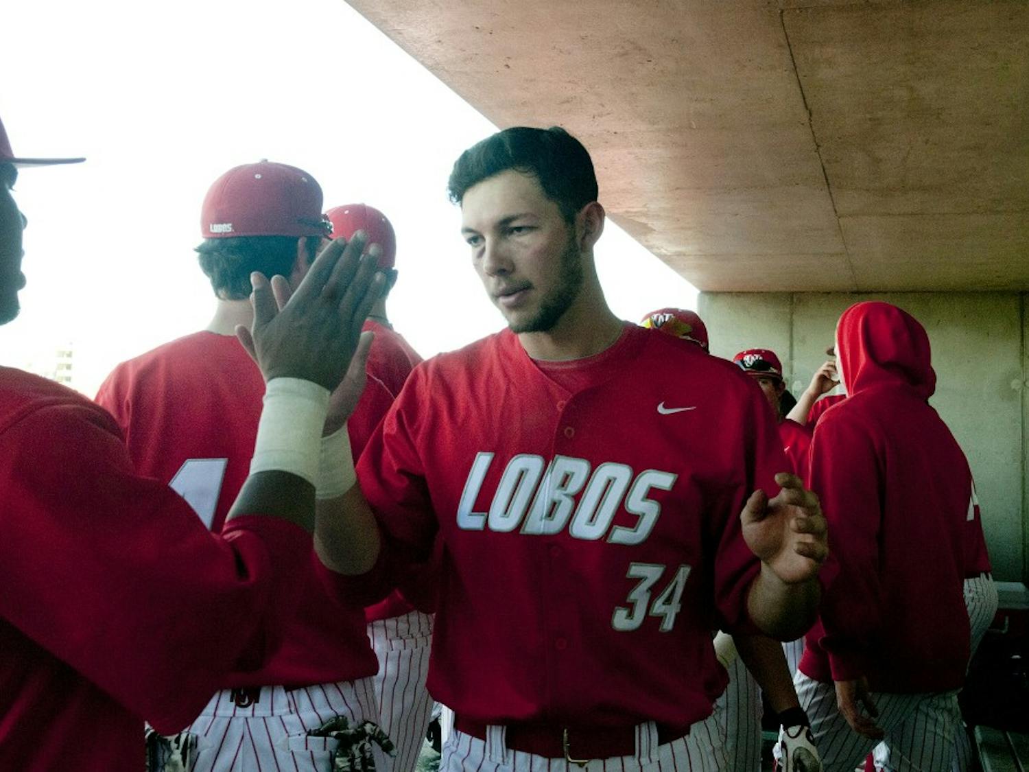 	First baseman Ryan Padilla gives his teammates a high-five during the Northern Illinois game on Sunday. The Lobos defeated Missouri State 7-0 then tied Northern Illinois 3-3. It was UNM’s first tie since 2004 against Northwestern.