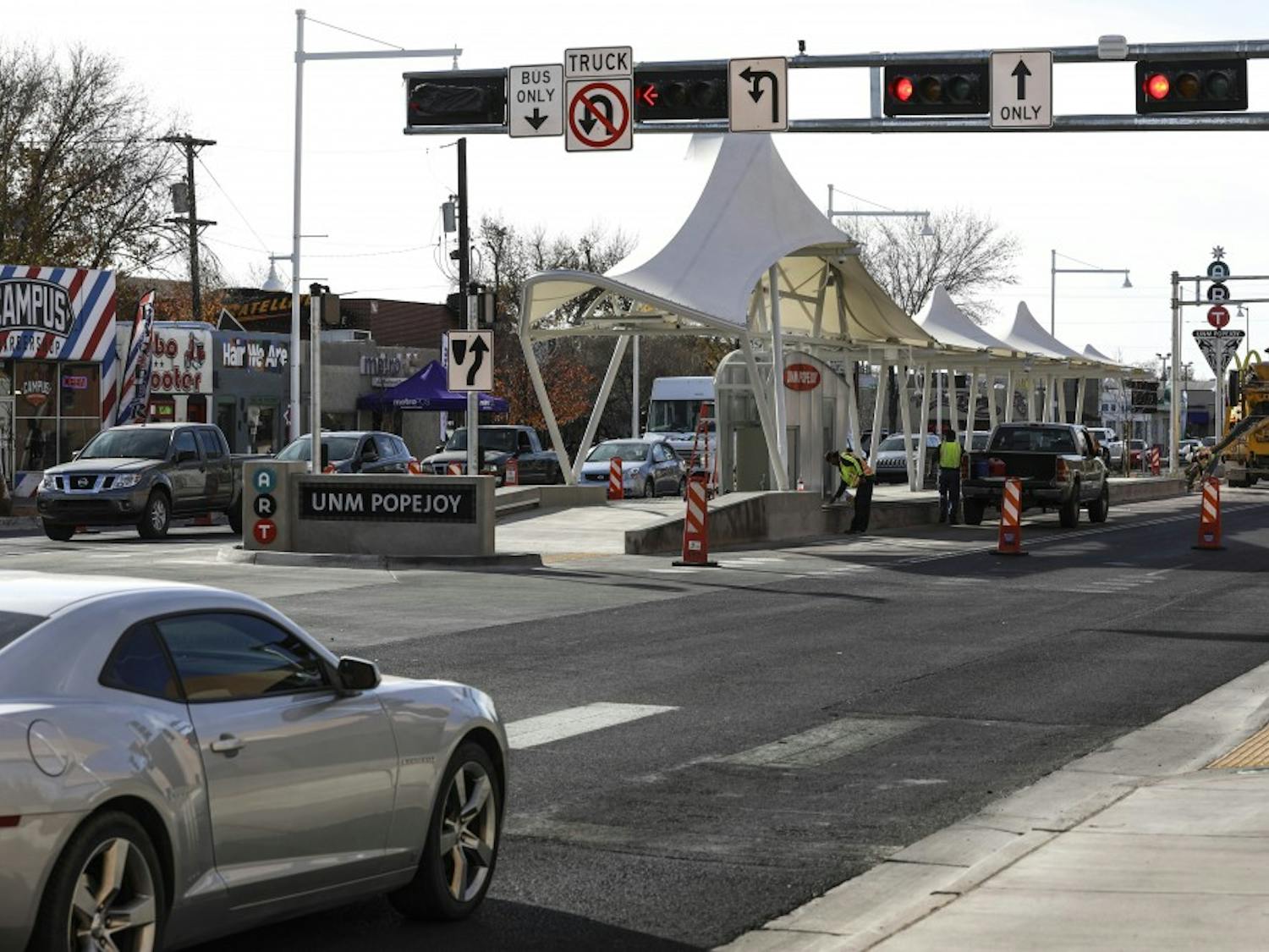 Cars pass the intersection of Central Ave. SE and Cornell Drive SE, near new street signs for the Albuquerque Rapid Transit system, Nov 29, 2017.