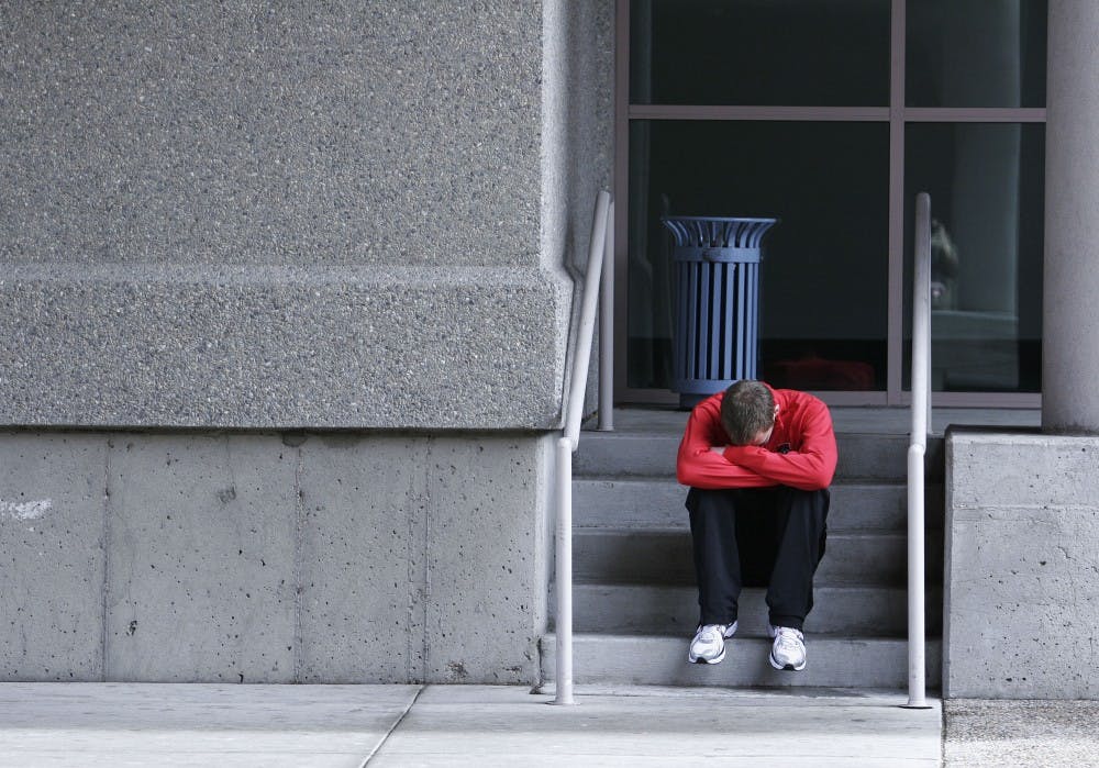 	Lee Emanuel sits dejectedly after coming in third place in the 800-meter run  nals on Saturday at the Albuquerque Convention Center.