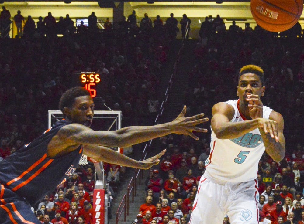 Lobo junior guard Arthur Edwards, 5, tosses the ball to lobo senior guard Deshawn Delaney, out of frame, during the game against Cal State Fullerton at the Pit on Sunday night. The Lobos defeated Cal State 67-59.