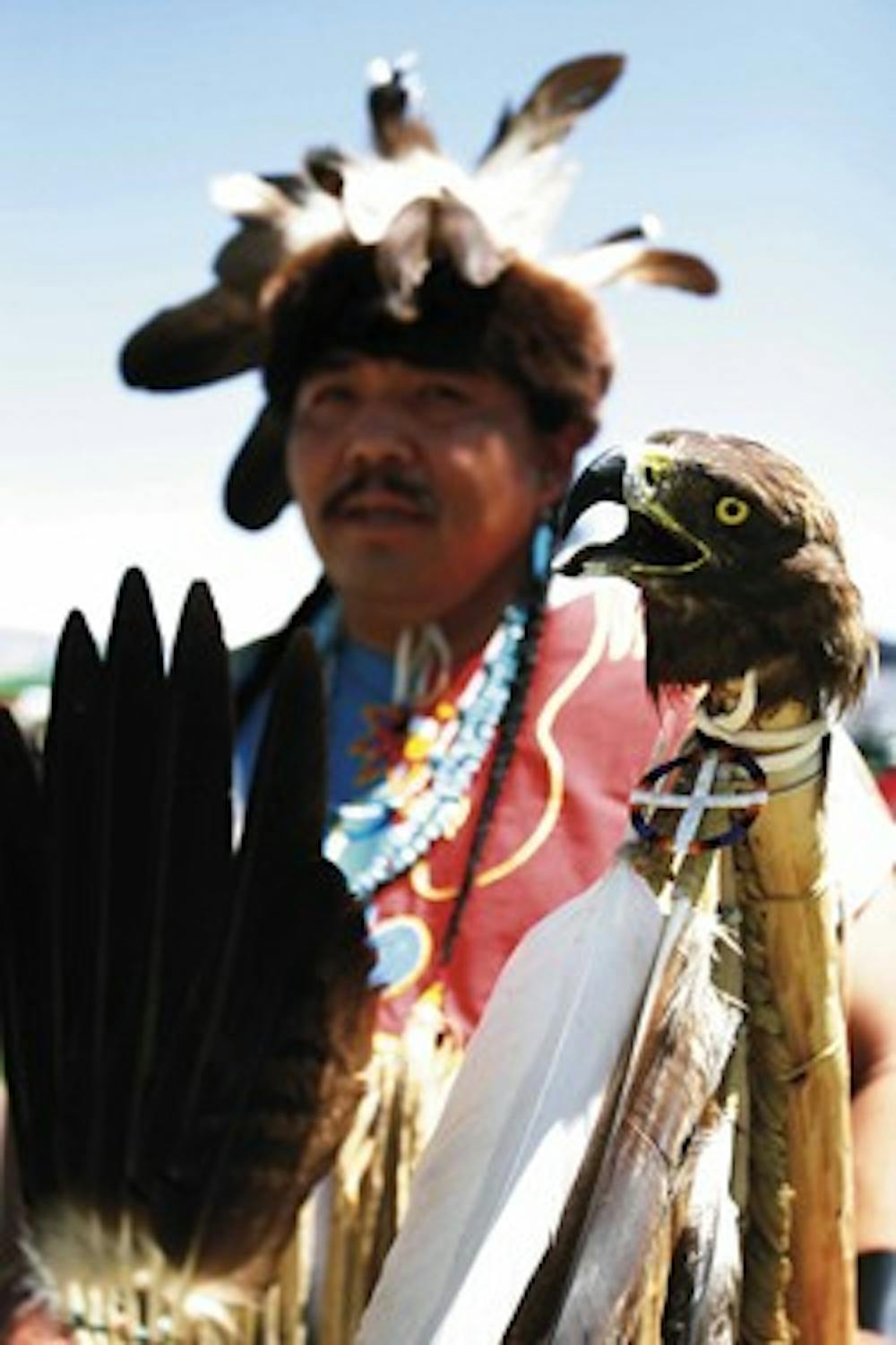 Wayne Wilson, a UNM-Gallup student, prepares to dance Sunday at the Nizhoni Days Powwow at Johnson Field. The eagle's head staff he's holding was given to him by his uncle, a Navajo Code Talker, who inspired Wilson to dance.