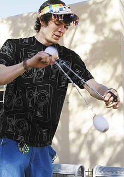 John Crandall practices spinning poi in front of Zimmerman Library on Monday. Crandall said he enjoys performing at raves. 