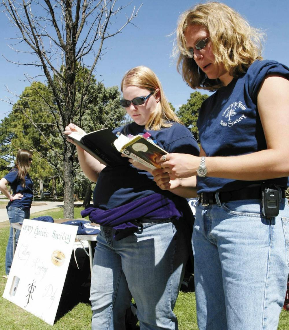 Julie Redekopp, treasurer of the UNM Hobbit Society, right, and member Megan Abrahamson read The Hobbit by J.R.R. Tolkien out loud Monday between Zimmerman Library and the Duck Pond.