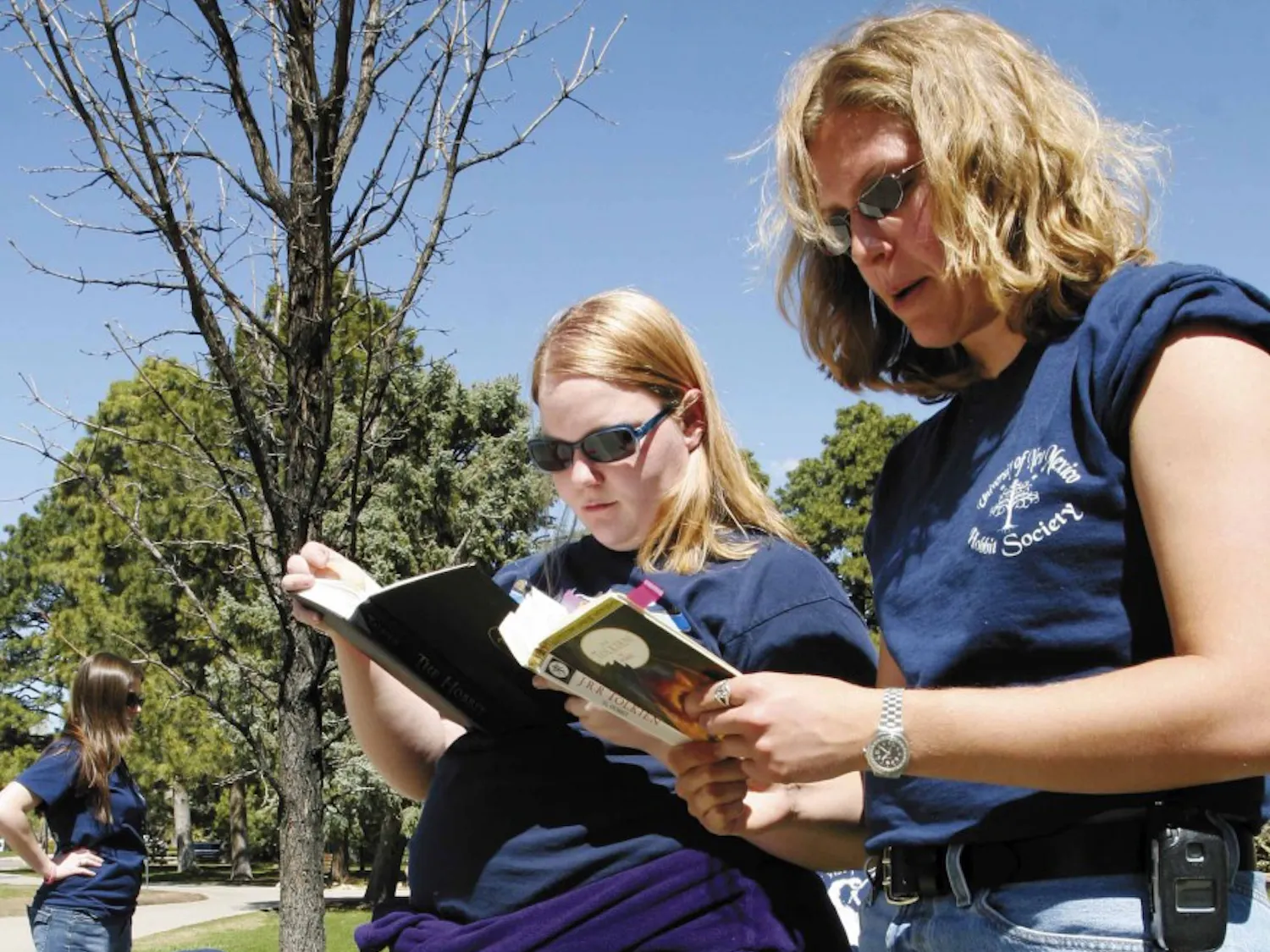 Julie Redekopp, treasurer of the UNM Hobbit Society, right, and member Megan Abrahamson read The Hobbit by J.R.R. Tolkien out loud Monday between Zimmerman Library and the Duck Pond.