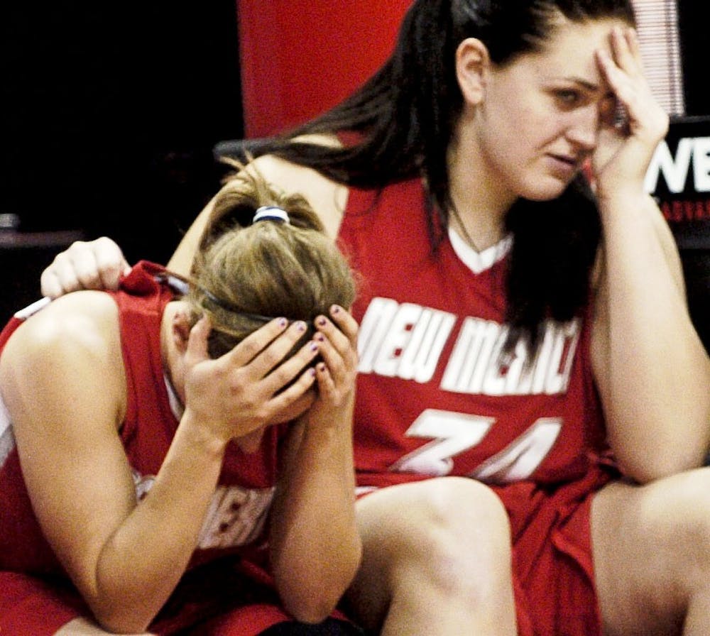 	Lobo guard Nikki Nelson, left, buries her face in her hands, as teammate Valerie Kast looks on in disappointment. The Lobos bowed out in the second round of the MWC tournament, falling 51-45 to No. 4 Utah.