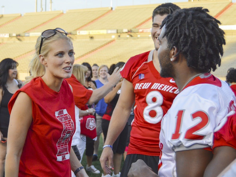 	Former Lobo Katie Hnida talks with Lobo senior quarterback Clayton Mitchem during the Women’s Football Clinic at University Stadium on Thursday evening. Hnida played three seasons for the Lobos as a walk-on placekicker from 2002 to 2004 and was the first woman to score points in an NCAA Division I football game.
