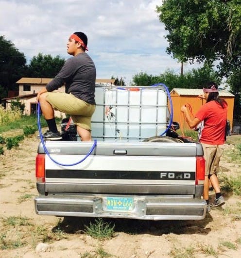 Demetrius Johnson and Cody Artis watering the cornfield.