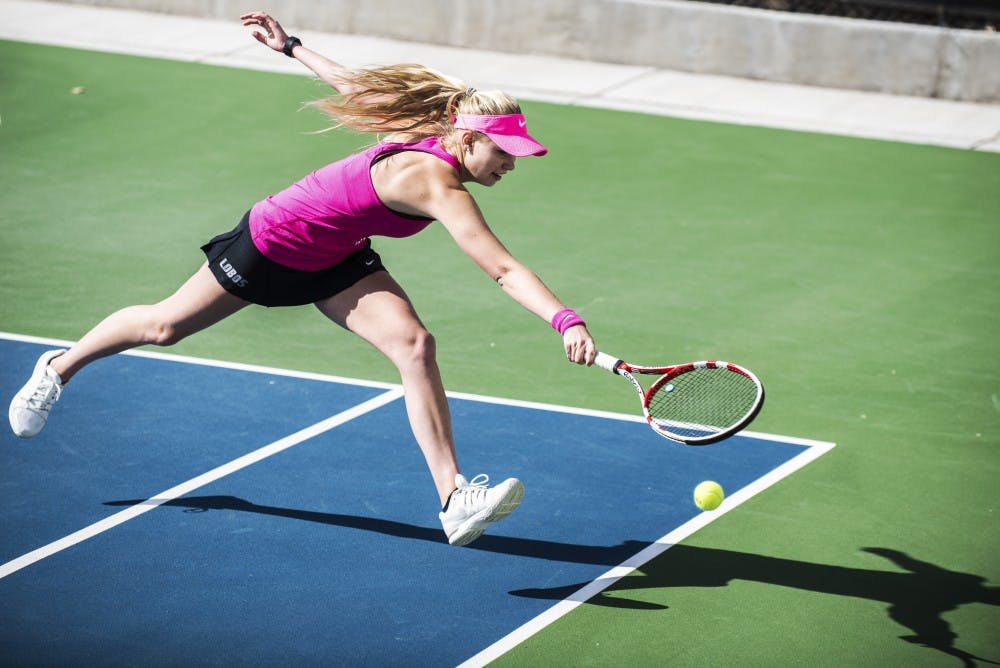 Junior Dominique Dulski jumps out for a ball Friday afternoon at the McKinnon Family Tennis Stadium. The Lobos beat Colorado State 7-0.