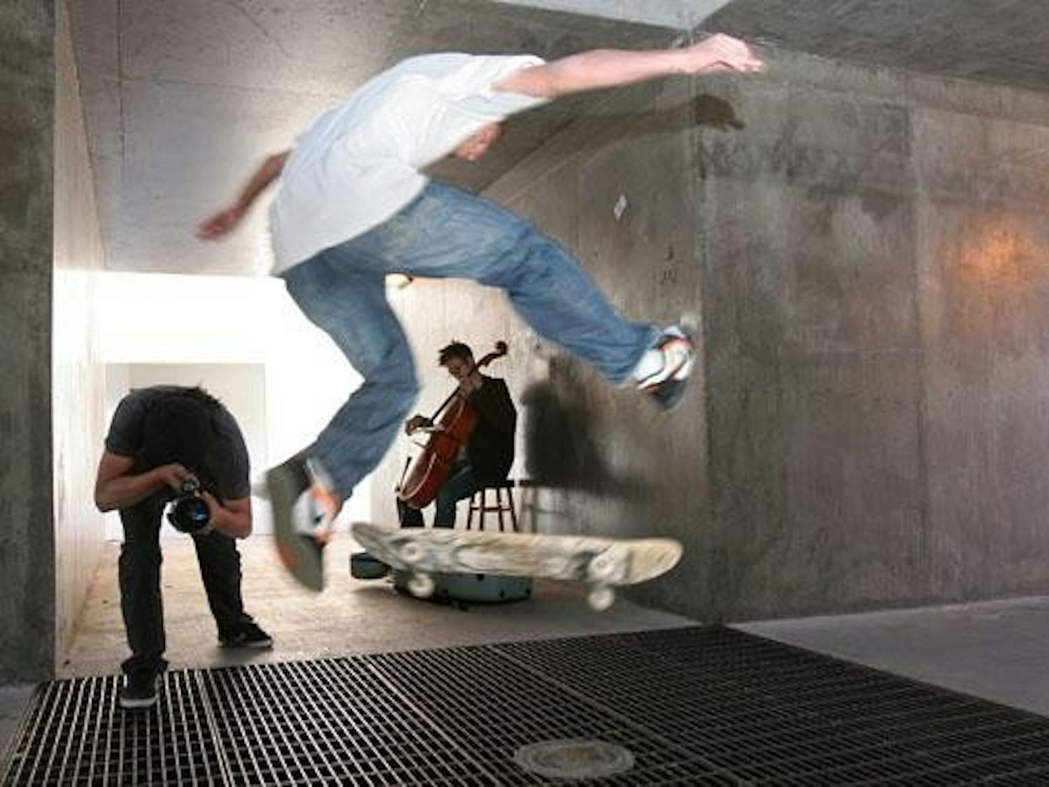 Brodie Johnson plays cello while Tony Tomita videotapes Derek Prada skateboarding at the Center of the Universe on Thursday.