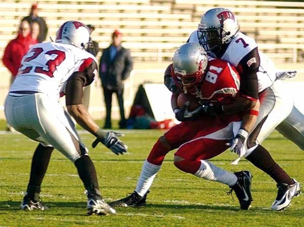 UNM wide receiver Travis Brown is tackled by UNLV's defensive back Geoffery Howard at University Stadium on Nov. 24. The Lobos will play Nevada in the New Mexico Bowl on Dec. 22.