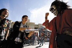 Student Carlos Rael, right, passes a petition Monday to students Jenica Houlberg, center, and Will McMain asking for the removal of Justice for All, an anti-abortion organization, from campus. 