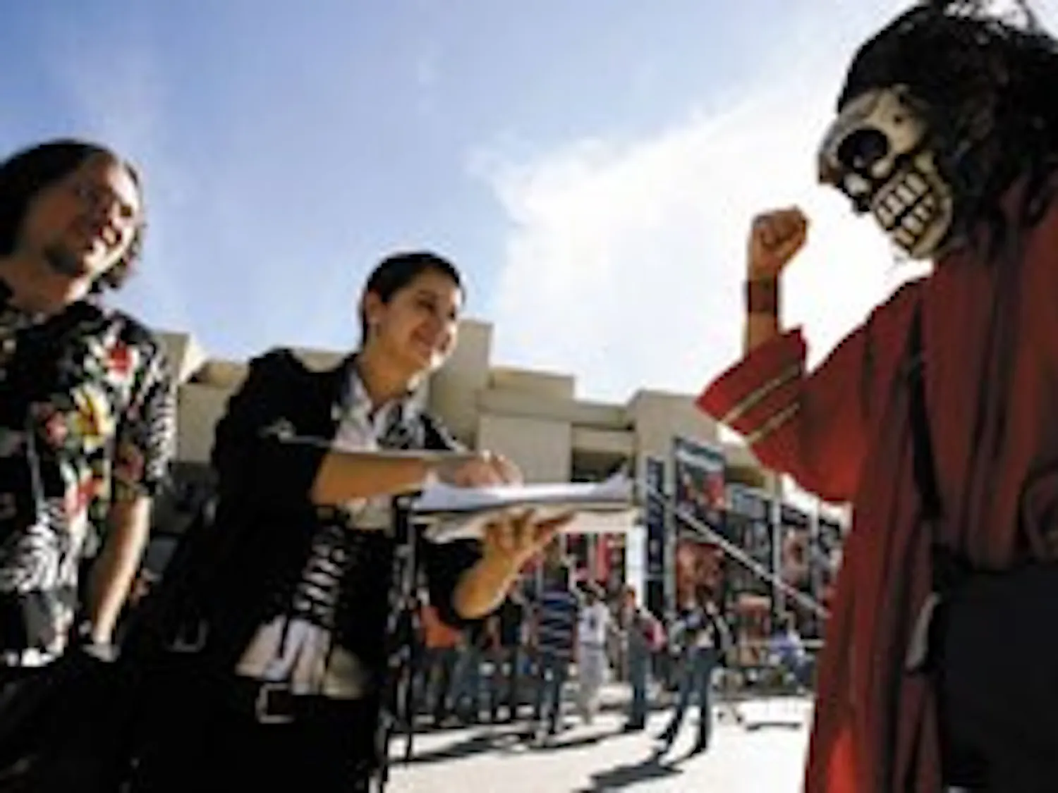 Student Carlos Rael, right, passes a petition Monday to students Jenica Houlberg, center, and Will McMain asking for the removal of Justice for All, an anti-abortion organization, from campus.