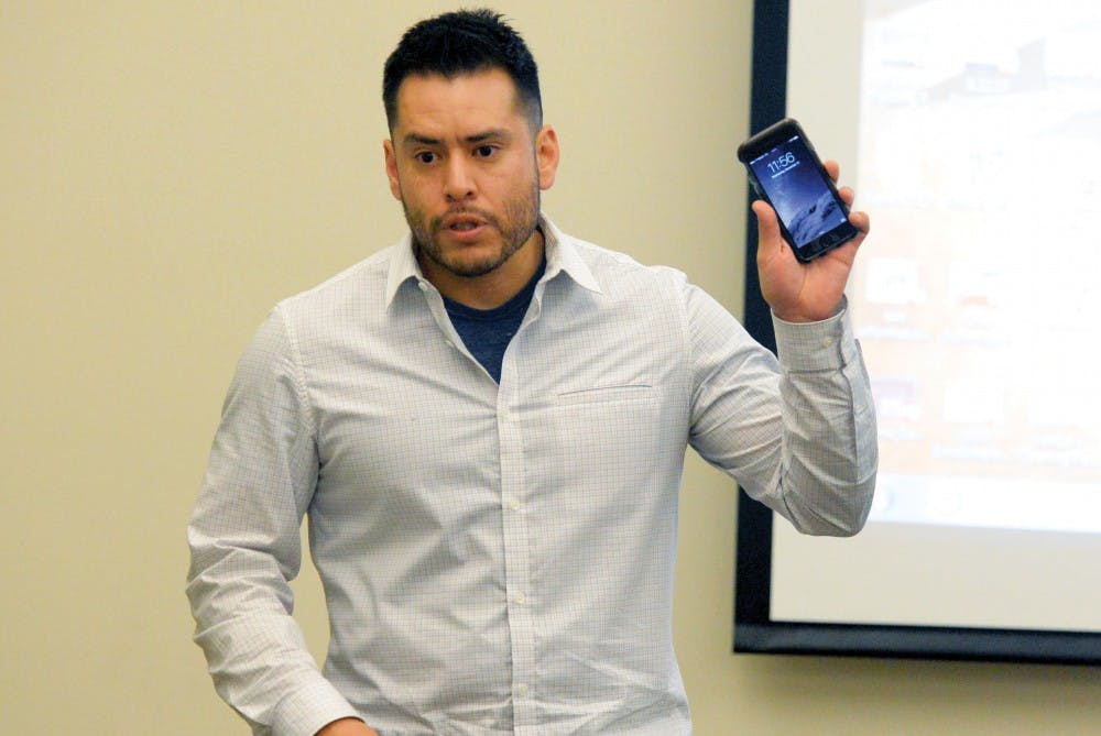 Preston Sanchez, staff attorney at the New Mexico Center on Law and Poverty, shows a cell phone at the “Your Constitutional Rights” seminar at the SUB Fiesta room on Wednesday afternoon. Sanchez touched on how to act when being questioned by law enforcement.