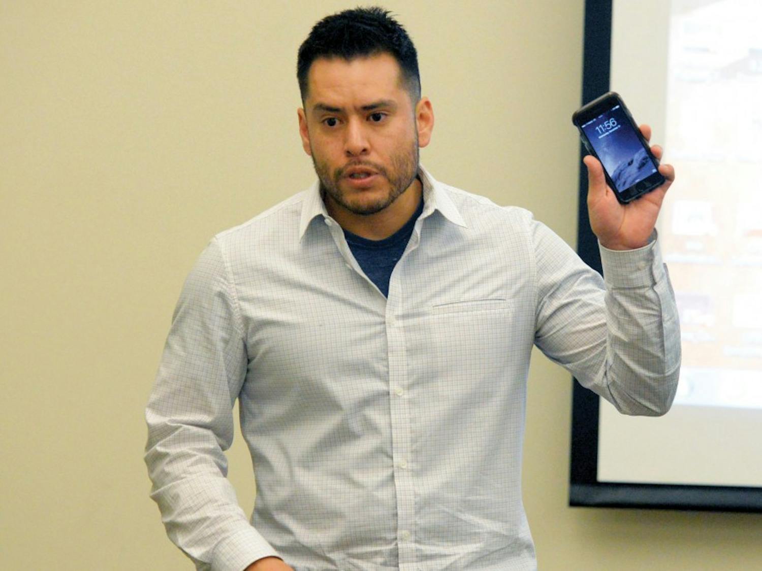 Preston Sanchez, staff attorney at the New Mexico Center on Law and Poverty, shows a cell phone at the “Your Constitutional Rights” seminar at the SUB Fiesta room on Wednesday afternoon. Sanchez touched on how to act when being questioned by law enforcement.