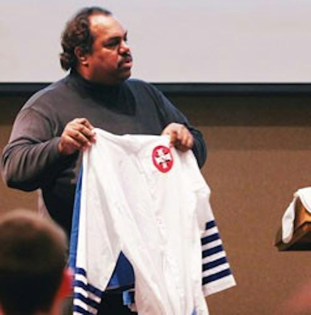 Daryl Davis holds a Ku Klux Klan robe during a presentation in the SUB on Wednesday. Davis spoke to more than 100 people about his work with white supremacists.