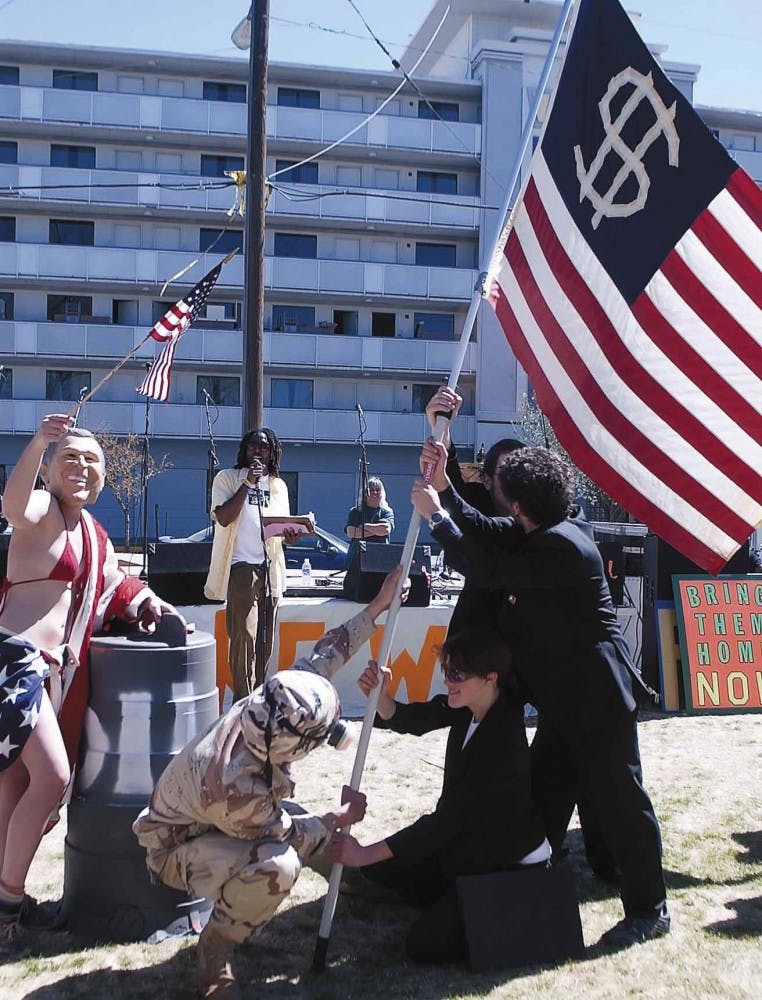 The performance troupe La Cucaracha Stew Co. poses like the Iwo Jima Memorial during a protest against the Iraq war at Robinson Park on Saturday. 