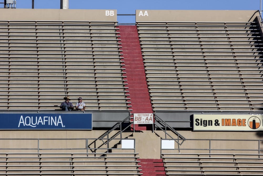 Two men talk while sitting in the Dreamstyle Stadium.
