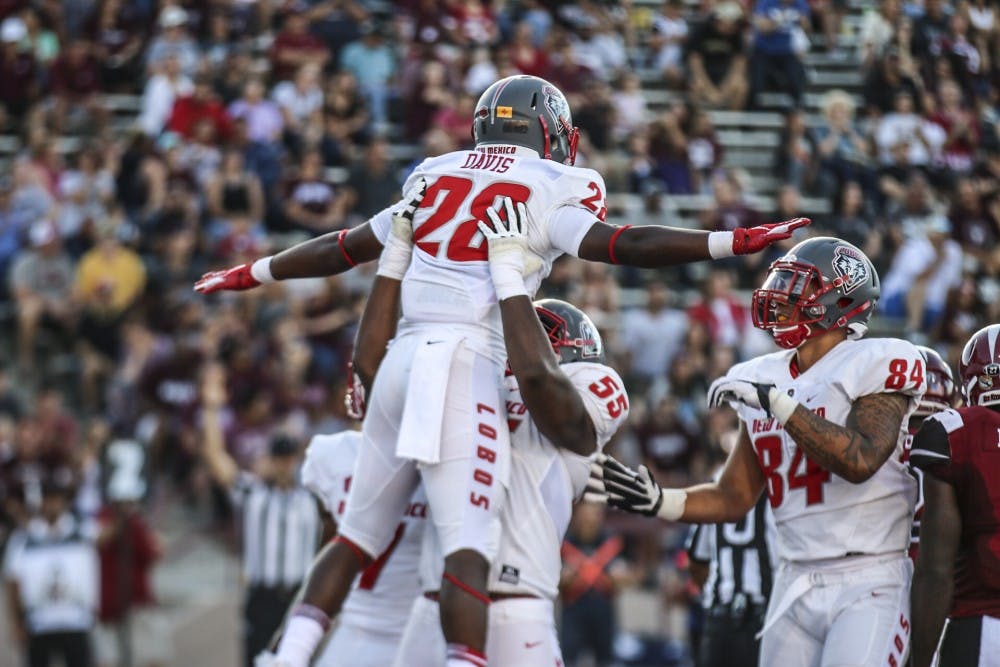 Ahmari Davis celebrates with Aaron Jenkins after scoring a touchdown against NMSU Saturday 16, 2018. The Lobos beat the Aggies 42-25.