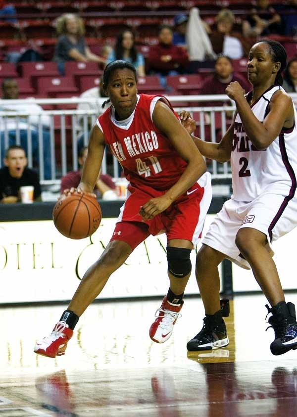 UNM guard Brandi Kimble dribbles while NMSU forward Sherell Neal defends during Sunday's 58-42 loss in Las Cruces. 