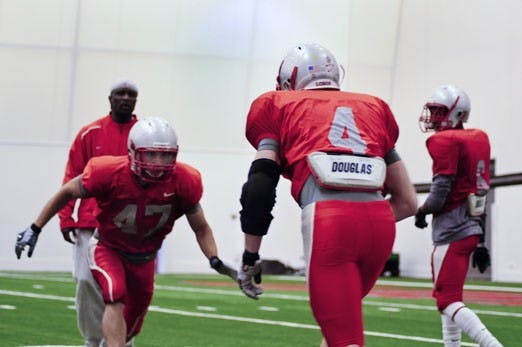 Cornerback Nathan Enriquez, left, clashes with teammate Jesse Paulsen during individual workouts Saturday. The Lobos have only four seniors returning in the secondary.