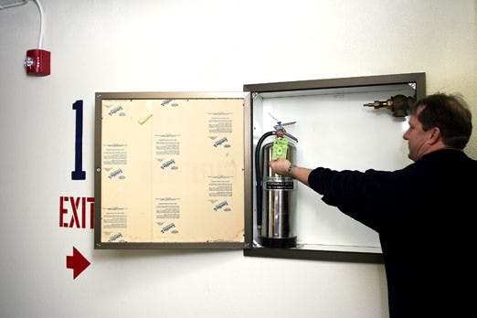 Bobby Childers, housing services representative, shows a green tag that signifies fire-safety precautions are up to date in Coronado Hall on Jan. 28.