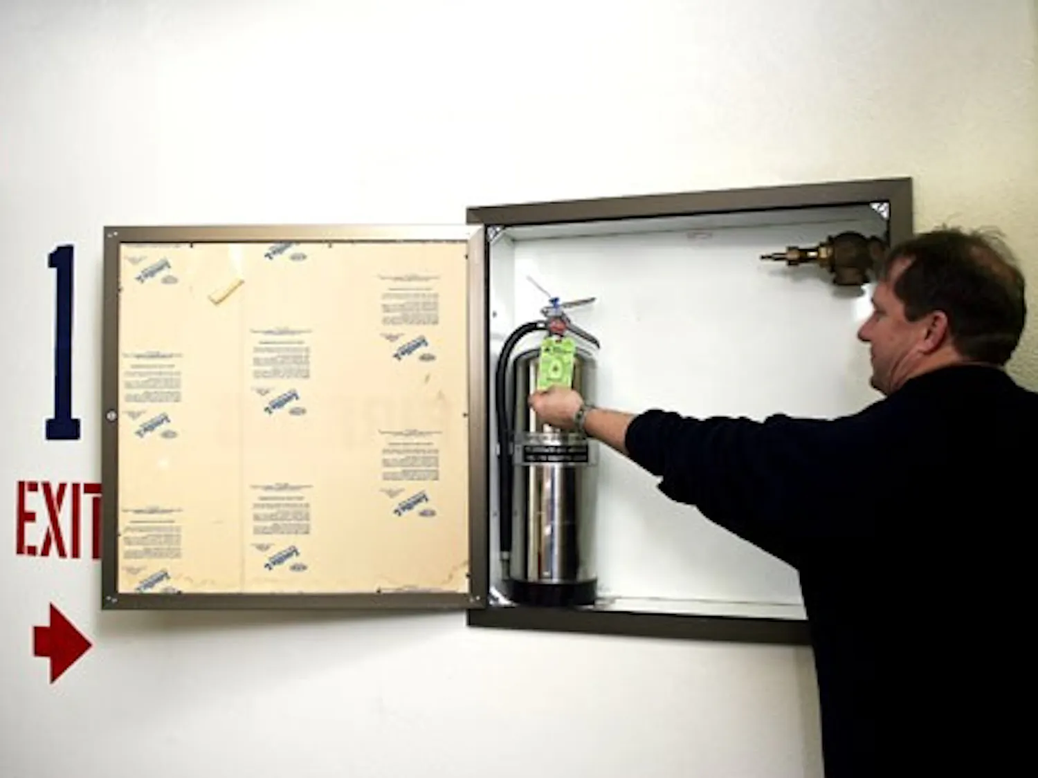 Bobby Childers, housing services representative, shows a green tag that signifies fire-safety precautions are up to date in Coronado Hall on Jan. 28.