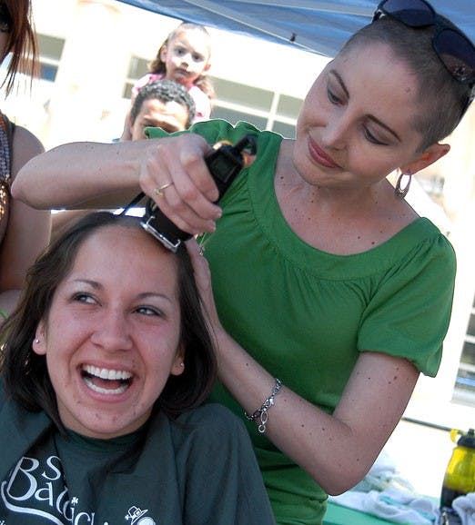 Student Jessica Gallegos gets her head shaved at a benefit for the St. Baldrick's Foundation at UNM Hospital on Saturday.