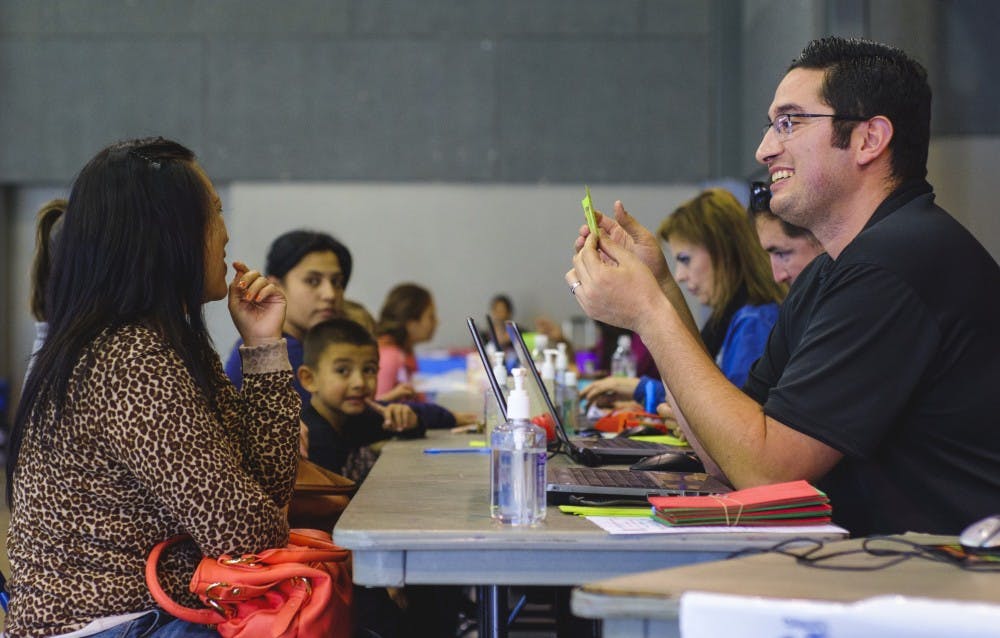 Raul Valencia helps a young mother register at the Toys For Tots registration at the Alamosa Center on November 19.