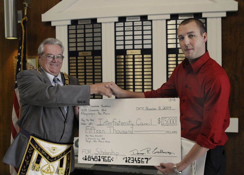 	Grand Masonic Lodge Grand Secretary Danny Calloway, left, presents Interfraternity Council President Michael Westervelt with a $15,000 check at the Grand Lodge on Sunday. The money is going towards an annual $750 scholarship to fraternity members and is the first of its kind. 