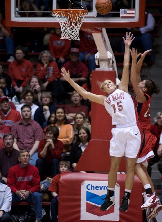 UNM guard Amanda Adamson tries to block a shot by Utah forward Halie Sawyer during the Lobos' 57-53 loss on Saturday at The Pit.