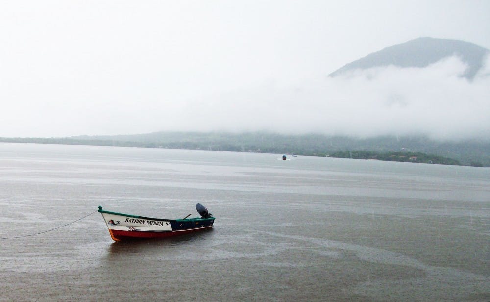 	A small boat floats lazily in the Pacific Ocean off the coast of Honduras.