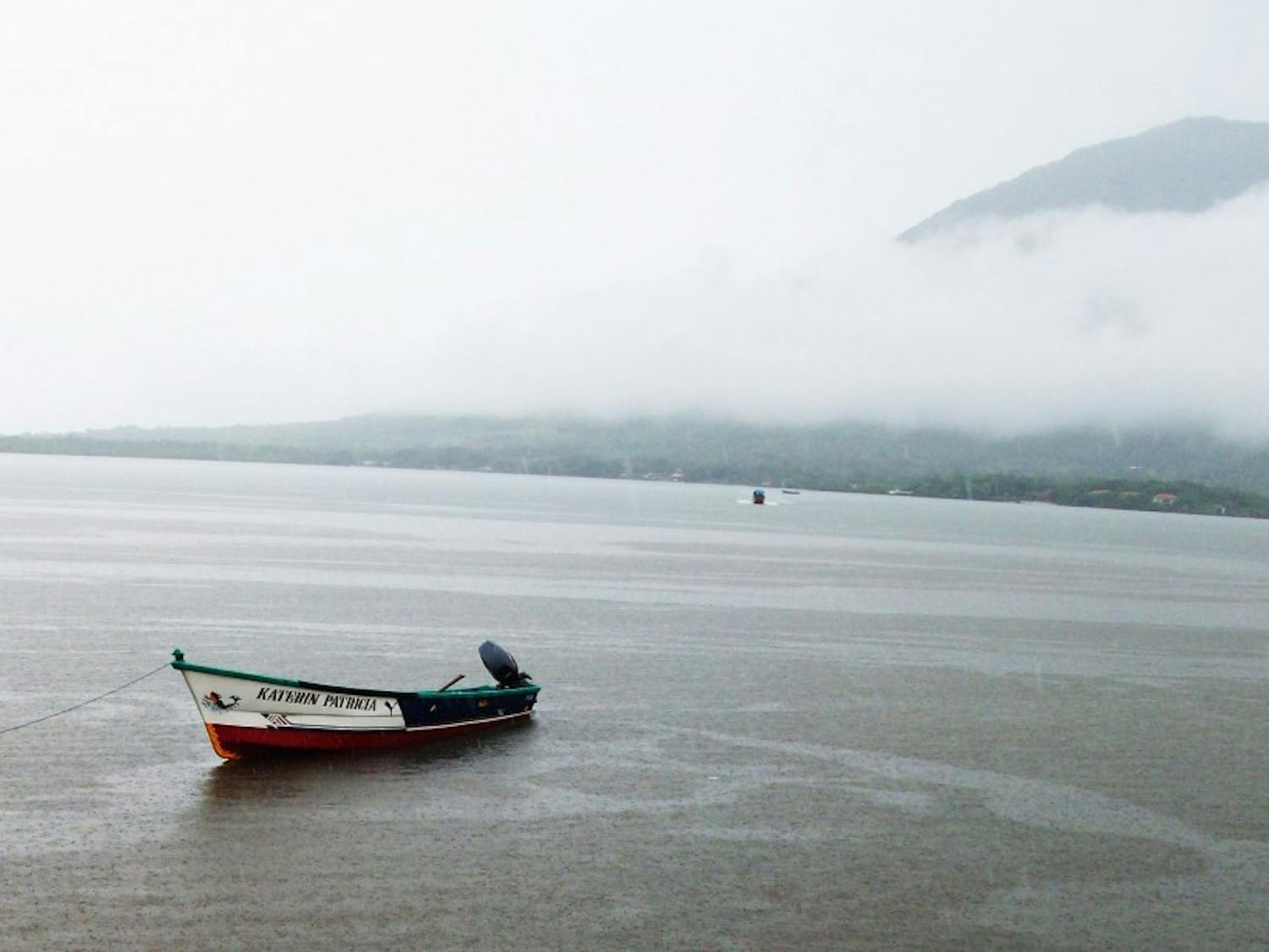A small boat floats lazily in the Pacific Ocean off the coast of Honduras.