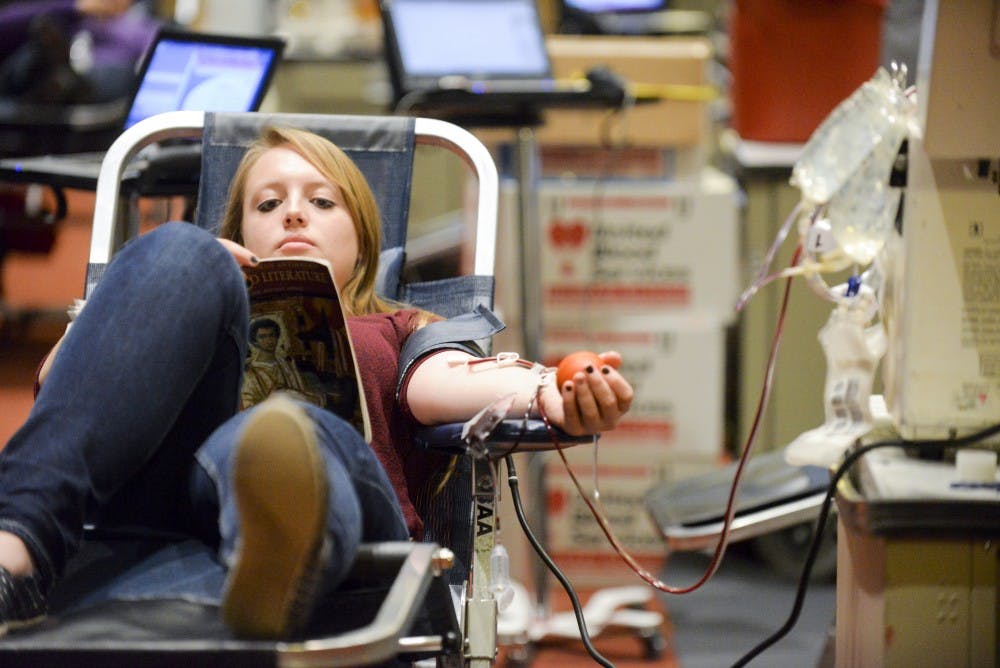 Alexis Gurrola reads while donating blood in the SUB Ballroom on Monday, February 1, 2015.&nbsp;