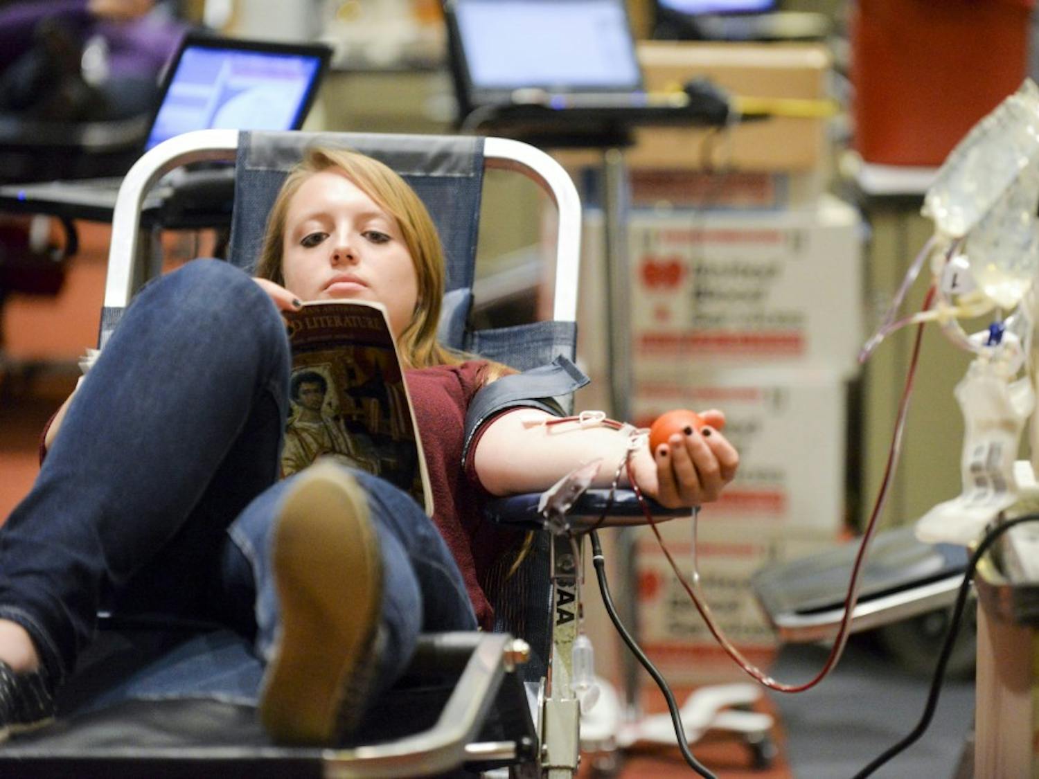Alexis Gurrola reads while donating blood in the SUB Ballroom on Monday, February 1, 2015.&nbsp;