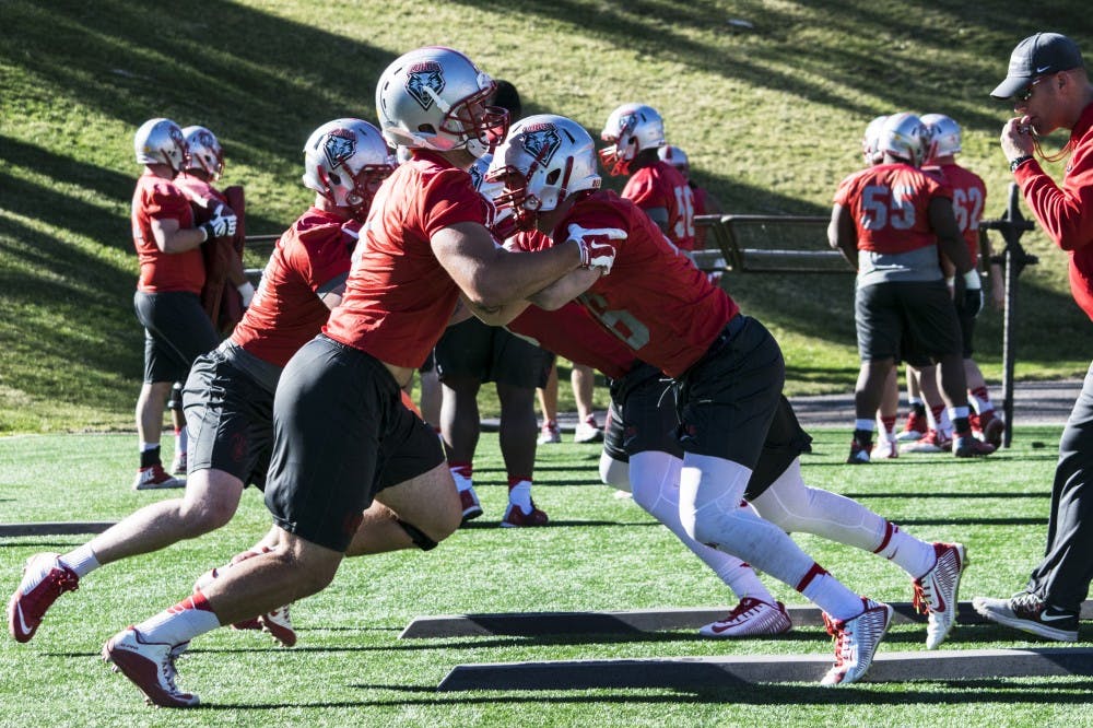Offensive Line coach Jason Lenzmeier runs over line drills with players Wednesday, March, 23, 2016 at University Stadium.