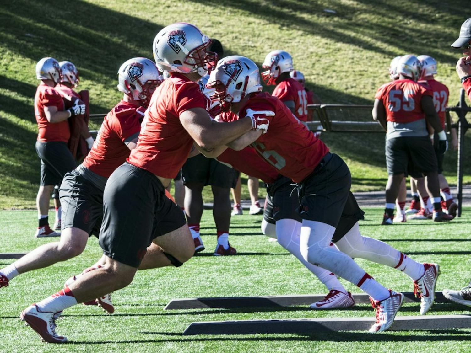Offensive Line coach Jason Lenzmeier runs over line drills with players Wednesday, March, 23, 2016 at University Stadium.