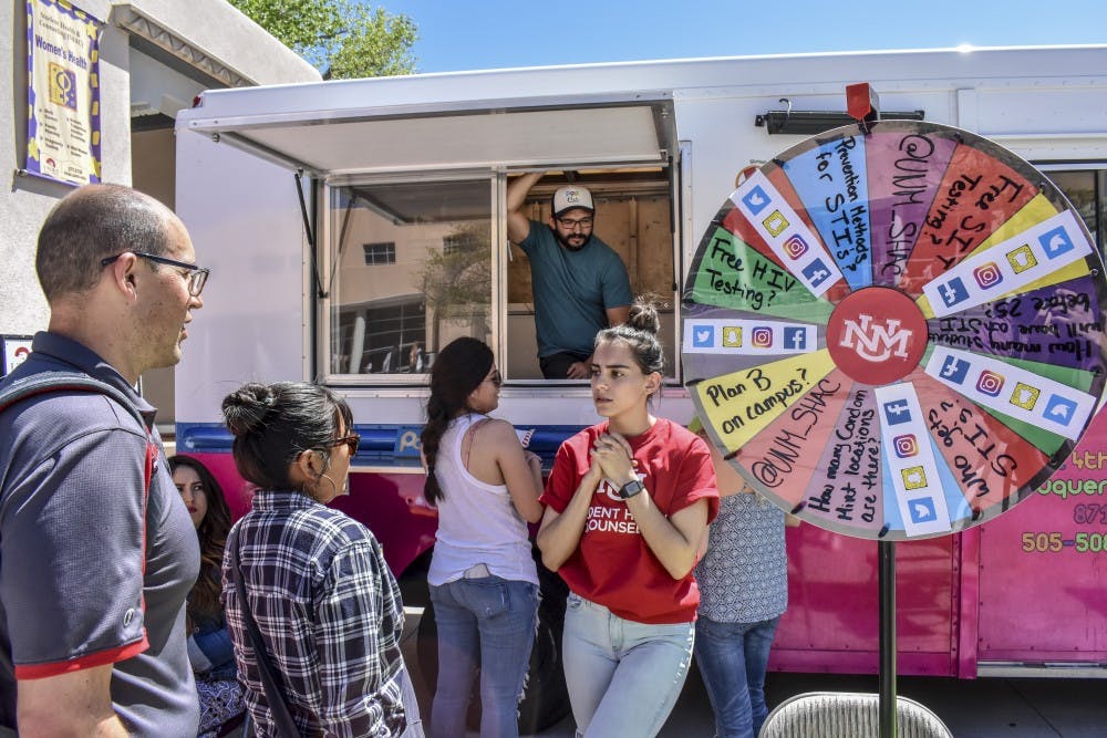 Representatives from UNM's Student Health and Counseling answer questions and give students paletas during SHAC’s condom-mint event celebrating the program's 7th anniversary on April 26, 2018.