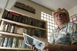 Acequia Booksellers owner Gary Wilkie skims through rare books and magazines July 25 at his store on Fourth Street.