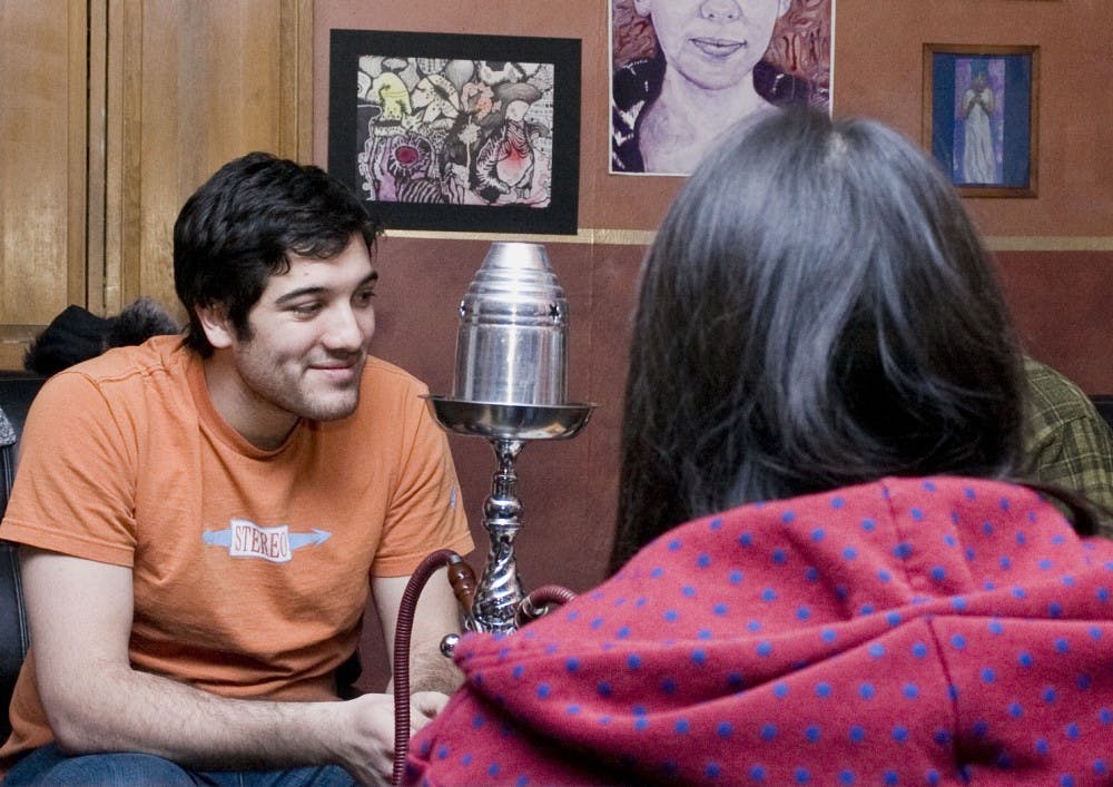 	Noah Silva, left, gets ready to smoke tobacco-less hookah with his friends at Terrene Hookah Lounge on March 1. Terrene uses dried tea leaves soaked in a sweet syrup for shisha instead of tobacco shisha.