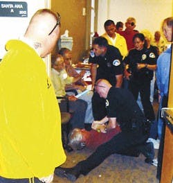 Robert Anderson, a Central New Mexico Community College professor and local antiwar activist, is arrested by UNM Police officers in the Santa Ana room in the SUB on Friday.