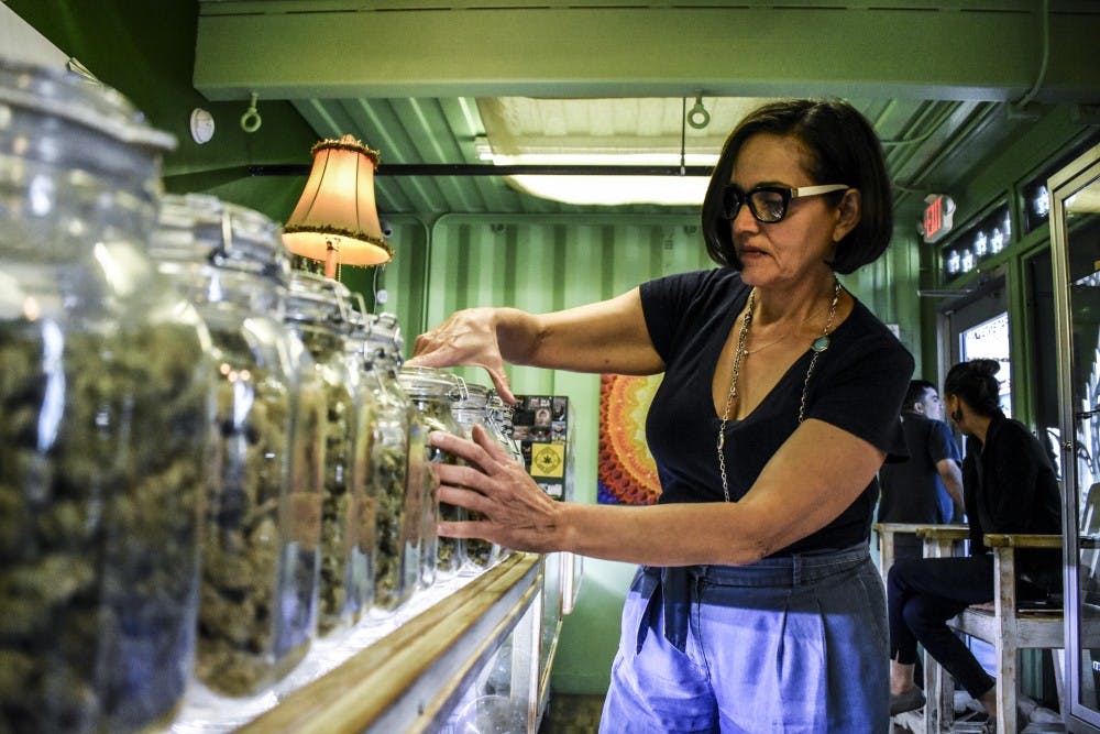 Sacred Garden Dispensary Manager Cecilia Gutierrez rearranges different cannabis strains.