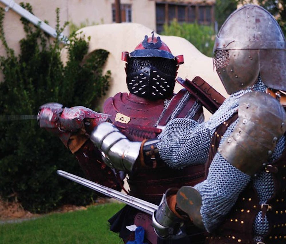 Intense Medieval Combat members Derek Robinson, left, and Derek Taylor battle during an exhibition match Aug. 8. The group is hosting a tournament at noon on Saturday at Roosevelt Park, where they will battle with real weapons and armor constructed in med