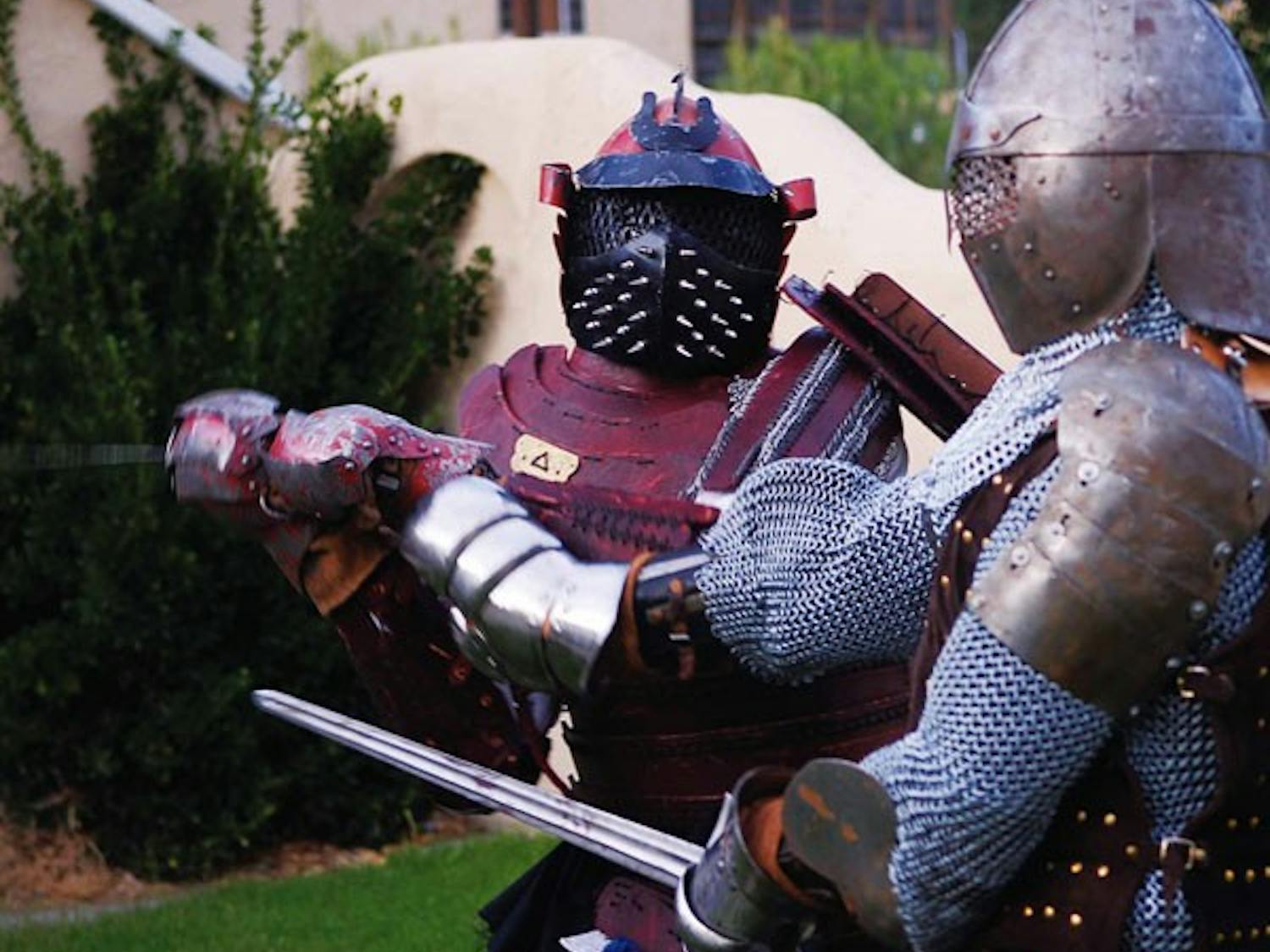 Intense Medieval Combat members Derek Robinson, left, and Derek Taylor battle during an exhibition match Aug. 8. The group is hosting a tournament at noon on Saturday at Roosevelt Park, where they will battle with real weapons and armor constructed in med