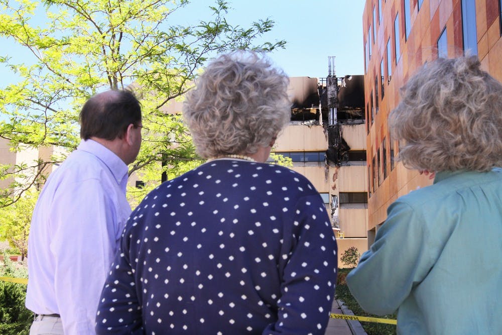 	Jay Parkes, left, Nancy Sinclair and Teresita McCarty look at the damage to the Biomedical Research Facility on north campus Wednesday. The fire began when the emergency generator was tested. The building burned for 30 minutes before being extinguished by the Albuquerque Fire Department.