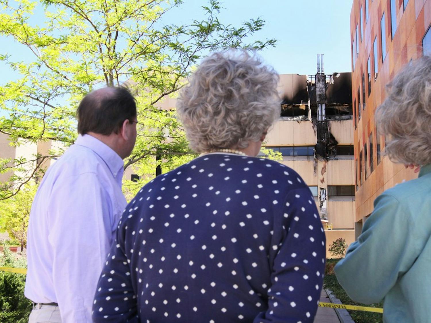 	Jay Parkes, left, Nancy Sinclair and Teresita McCarty look at the damage to the Biomedical Research Facility on north campus Wednesday. The fire began when the emergency generator was tested. The building burned for 30 minutes before being extinguished by the Albuquerque Fire Department.