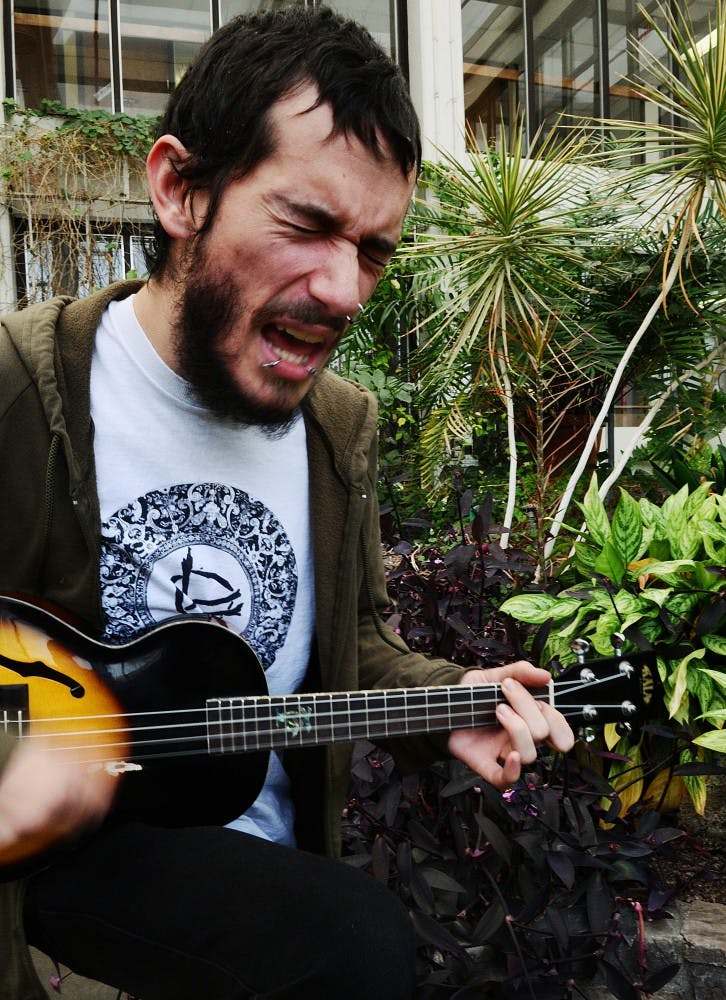 	Student Alex Denbaars serenades the plants in Castetter Hall’s biology greenhouse Monday. Denbaars plays the ukulele in a folk-punk band called Arroyo Deathmatch. Denbaars is the promoter for the house/venue called Heaven and Hell.
