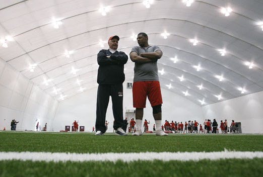UNM Athletic Trainer David Binder talks with Lobo football player Wesley Beck during Thursday's training in the Indoor Practice Facility. 